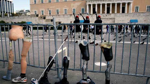 Manifestantes gregos com deficiência colocam suas próteses em frente ao Parlamento em ato contra corte de gastos, em 03/12/2012