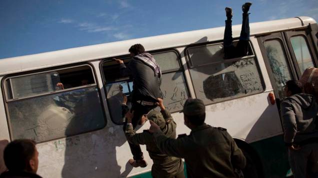 Refugiados egípcios tentam embarcar em ônibus na cidade de Ras Jedir, na fronteira entre a Tunísia e a Líbia. Durante os confrontos entre rebeldes e as forças pró-Kadafi milhares de pessoas se refugiaram na Tunísia