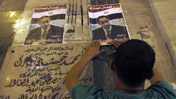 Cairo: Homem cola cartazes pedindo a candidatura de Gamal Mubarak