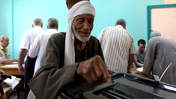 Eleitor deposita cédula em urna no Egito: Ahmed Shafiq e Mohammed Mursi disputam a Presidência