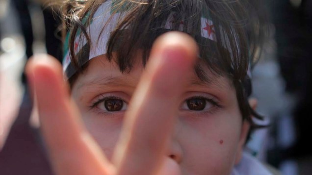 Garoto sírio que vive no Egito durante protesto contra o presidente da Síria, Bashar al-Assad, no Cairo, Egito