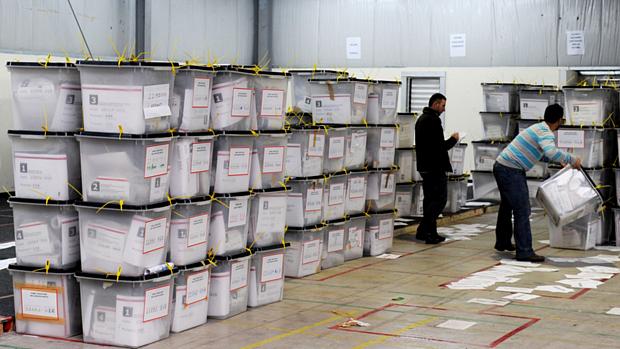 Oficiais organizam caixas em centro de contagem, após eleição