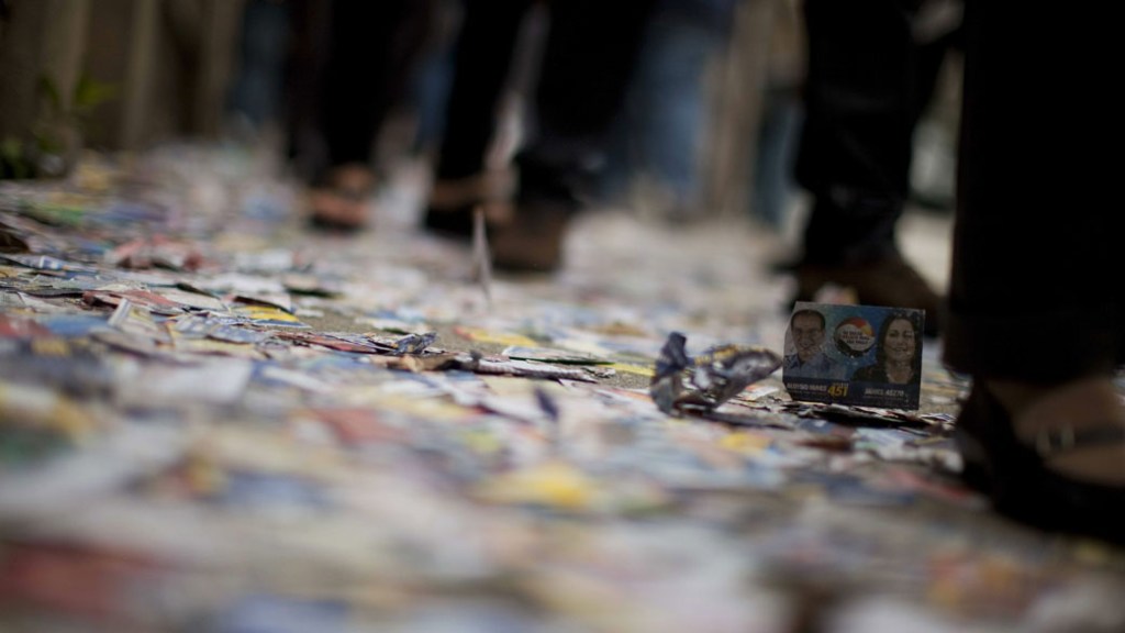 Eleitores caminham sobre santinhos jogados nas ruas de São Paulo