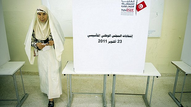 Tunisiana deixa cabine de votação. Estima-se que 7,3 milhões de eleitores compareçam às urnas