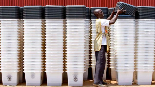 Homem organiza urnas que serão usadas nas eleições multipartidárias de Uganda
