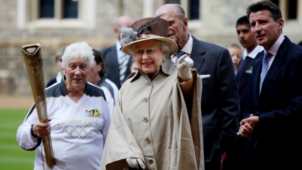 Elizabeth II recebeu a tocha olímpica na companhia do marido e do presidente do Comitê Organizador da Olímpiada
