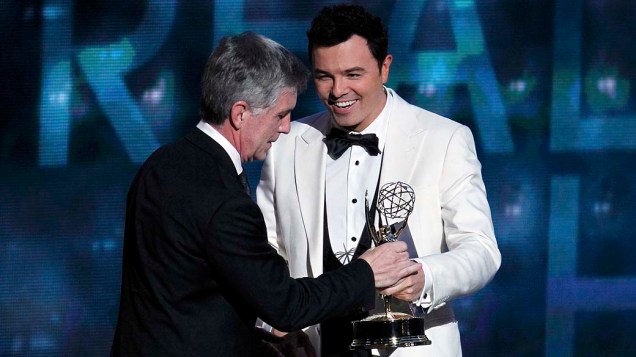 Seth MacFarlane entrega o prêmio de melhor apresentador de reality show para Tom Bergeron de Amazing Race