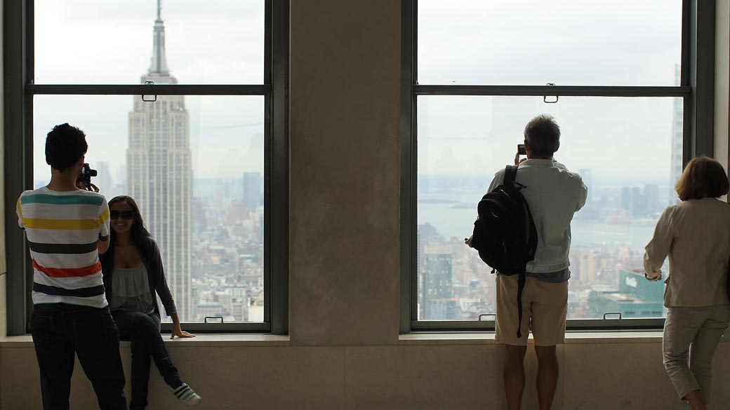 Turistas observam o Empire State, o edifício mais alto de Nova York