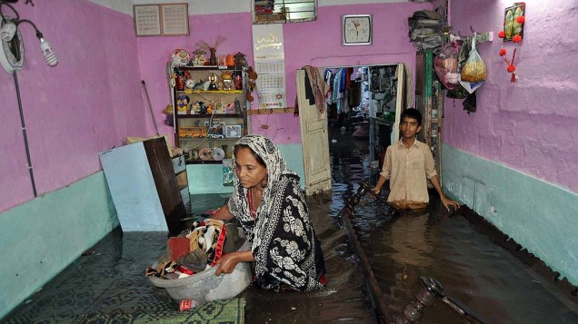 Em Hyderabad, paquistaneses tentam salvar seus pertences em meio a enchente