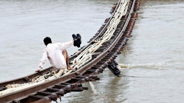 Travessia de linha férrea arrastada pelo rio Gai, na cidade de Dhemaji, devido às enchentes na Índia