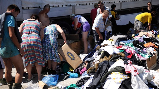 Moradores recebem doação de roupas secas após inundações na cidade de Krymsk, no sul da Rússia