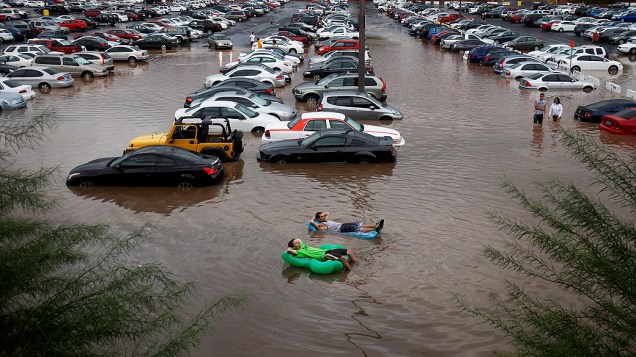 Estudantes são vistos relaxando em boias em uma área alagada no estacionamento da Universidade de Nevada, em Las Vegas (EUA). A região foi atingida por fortes chuvas