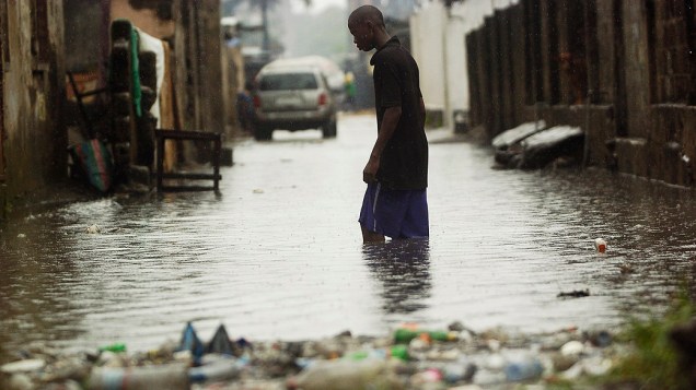 Morador anda por área alagada em Kinshasa, no Congo