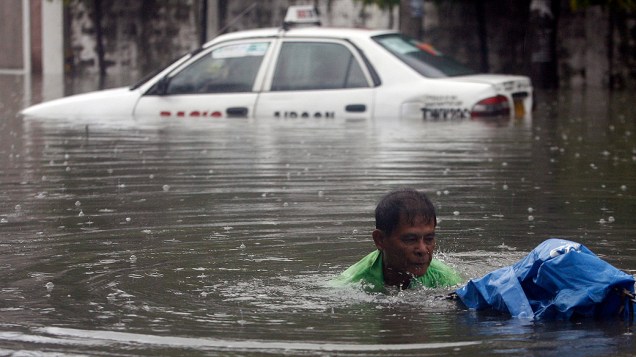 Equipes de resgates auxiliam pessoas em ruas alagadas em Manila, nas Filipinas. Algumas escolas da capital do país precisaram cancelar as aulas nesta terça-feira