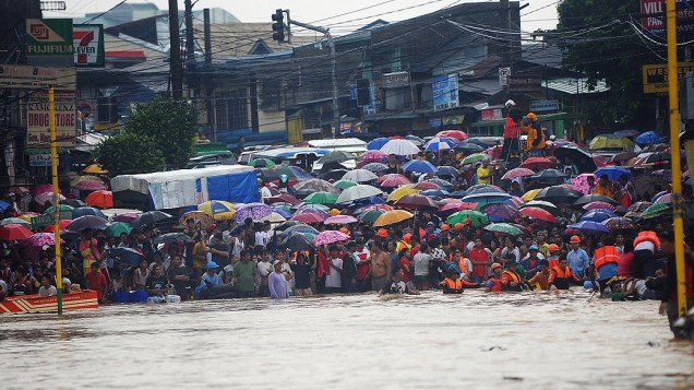 Moradores ficam presos por causa de rua alagada na região metropolitana de Manila, nas Filipinas