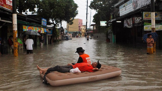Equipes de resgate descansam em colchão inflável, na região metropolitana de Manila, nas Filipinas