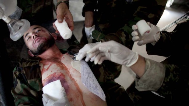 Estudantes atendem um soldado ferido no hospital militar Davoud Khan em Cabul, Afeganistão