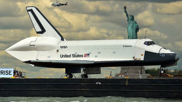 Barco leva o ônibus espacial Enterprise pelo rio Hudson, em Nova York (EUA). O destino da espaçonave é o museu Intrepid Sea