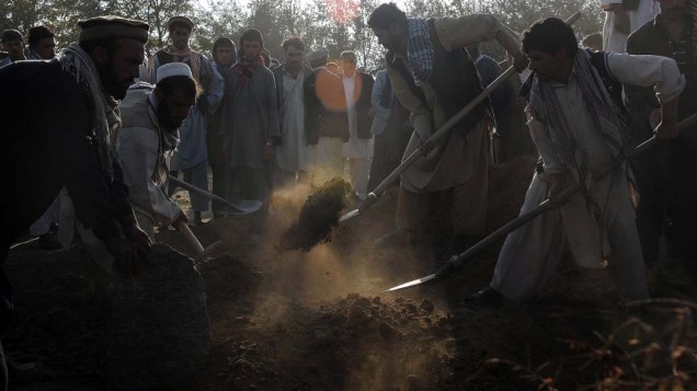 Afegãos enterram vítimas de explosão de um tanque de combustível perto da base aérea de Bagram, no Afeganistão