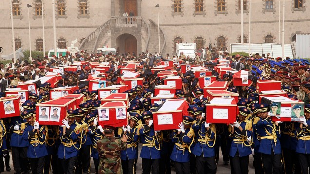 Guarda de honra iemenita carrega caixões dos soldados mortos em atentado suicida, durante procissão funerária em Sanaa. Pelo menos 70 pessoas morreram no atentado