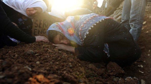 Mulheres choram durante enterro das vítimas do ataque aéreo turco contra curdos no cemitério de Gulyazi, Turquia