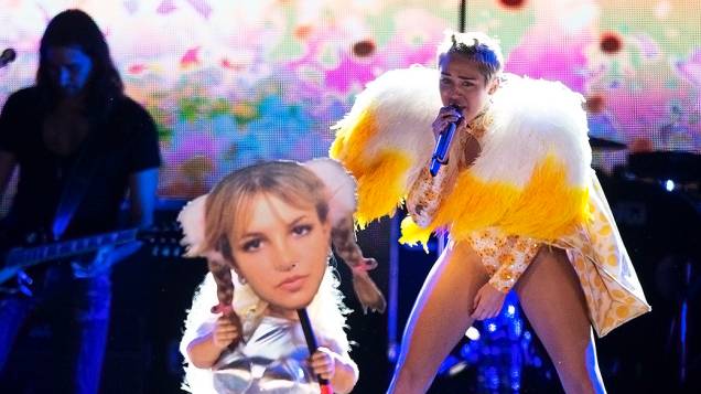 Uma anã aparece segurando uma máscara com o rosto da cantora Britney Spears, durante o show de Miley Cyrus no Anhembi, em São Paulo