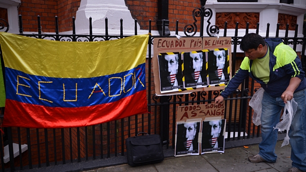 Manifestante coloca cartazes em apoio a Julian Assange na embaixada do Equador em Londres