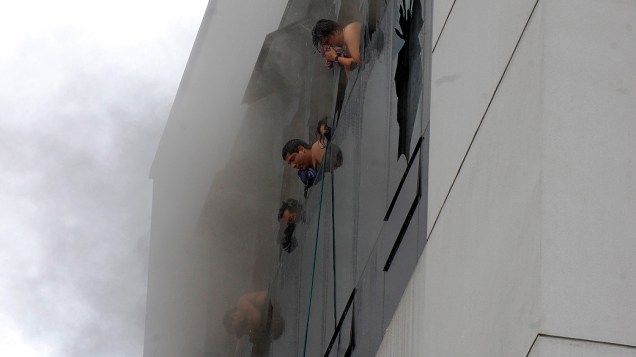 Vítimas tentam respirar em janelas durante incêndio em prédio comercial em Guayaquil, no Equador, nesta terça-feira