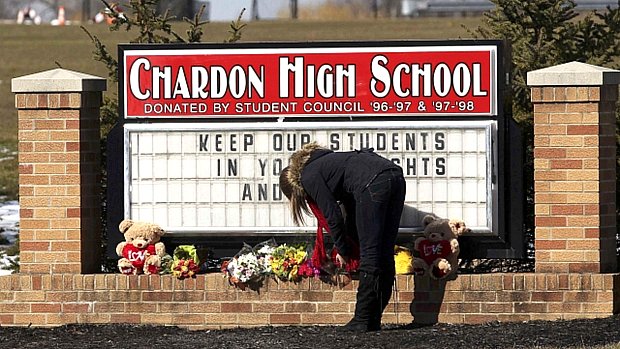 Mulher deixa flores em frente a escola de Chardon, em Ohio