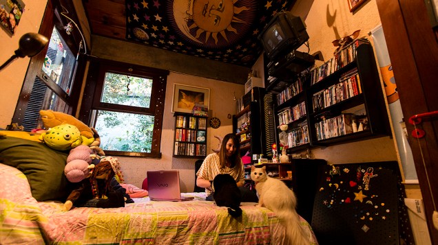 A escritora mineira com seus dois gatos em sua casa, em Belo Horizonte