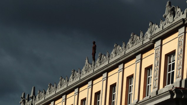 Figura de um homem feito de ferro e fibra de vidro pelo escultor britânico Antony Gormley, vista em telhado de um prédio no centro do Rio de Janeiro