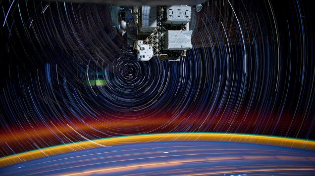 Imagem composta mostra um turbilhão de estrelas girando em volta da terra de uma câmera montada na Estação Espacial Internacional. Um total de 18 imagens foram usadas para criar essa composição