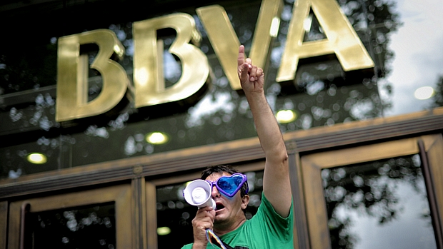 Manifestante protesta contra a crise em frente a uma agência do BBVA, em Barcelona