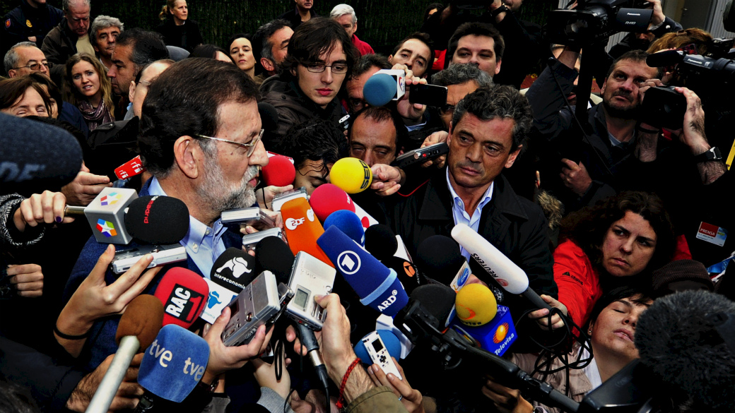 Mariano Rajoy, favorito nas eleições espanholas, cercado de repórteres, após votação
