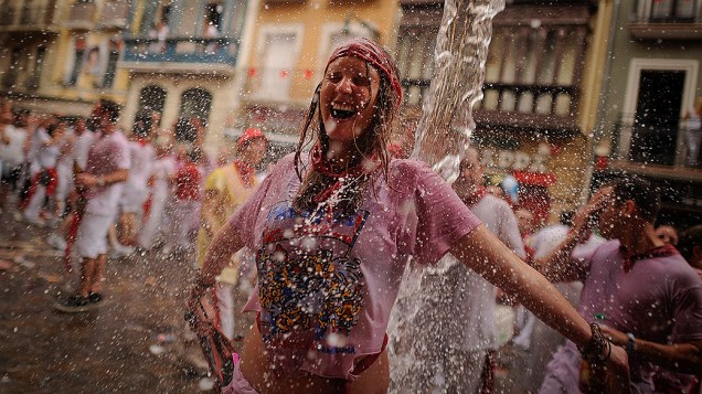 Participantes são borrifados com água durante a celebração do festival de São Firmino, em Pamplona na Espanha