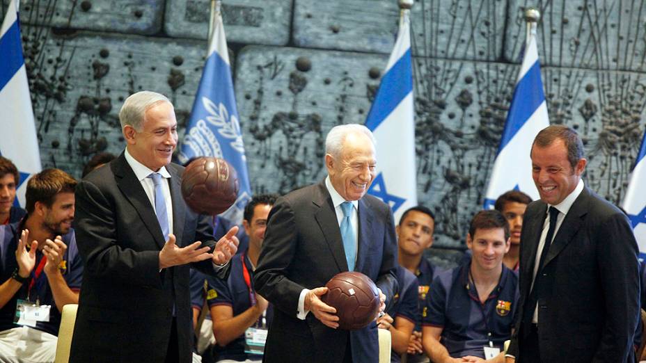 O presidente de Israel, Shimon Peres (C), e o primeiro-ministro, Benjamin Netanyahu (E), recebem uma bola do FC Barcelona do presidente do clube, Sandro Rosell, durante recepção na residência de Peres, em Jerusalém
