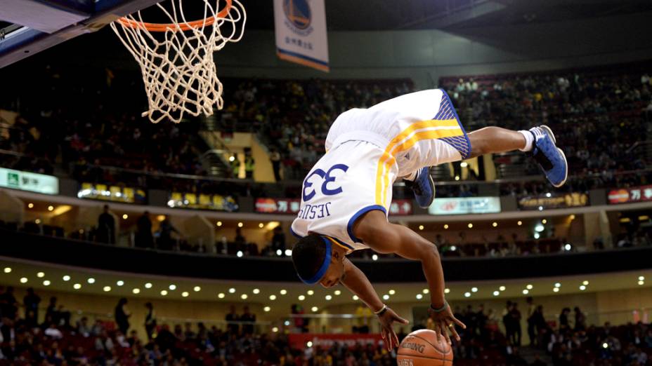 Jogador da equipe de acrobacias do Golden State Warriors, usa cama elástica para dar uma enterrada durante exibição antes da partida contra o Los Angeles Lakers em Pequim, na China