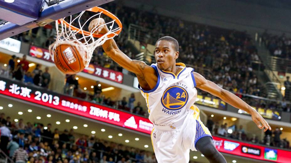 Jogador da equipe de acrobacias do Golden State Warriors, usa cama elástica para dar uma enterrada durante exibição antes da partida contra o Los Angeles Lakers em Pequim, na China