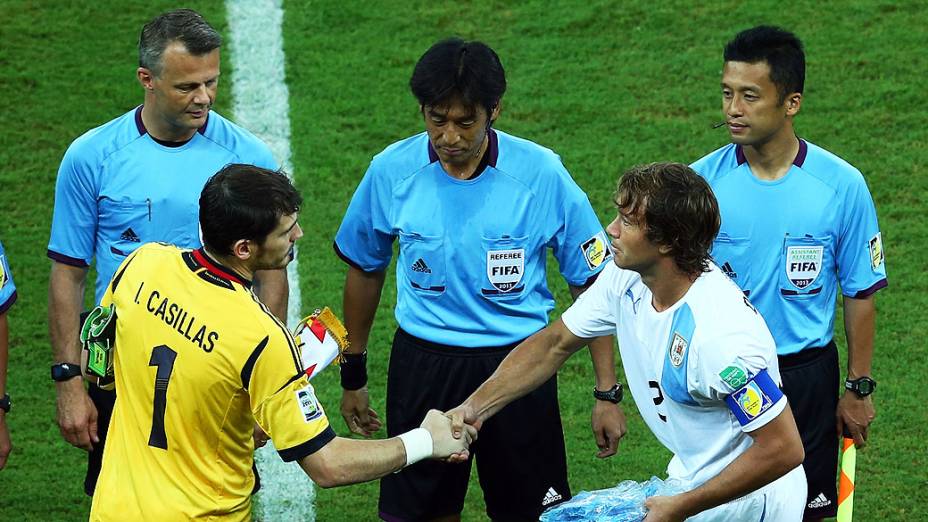 Os capitães Casillas e Diego Lugano (Uruguai): passeio da Espanha na reestreia do goleiro do Real Madrid