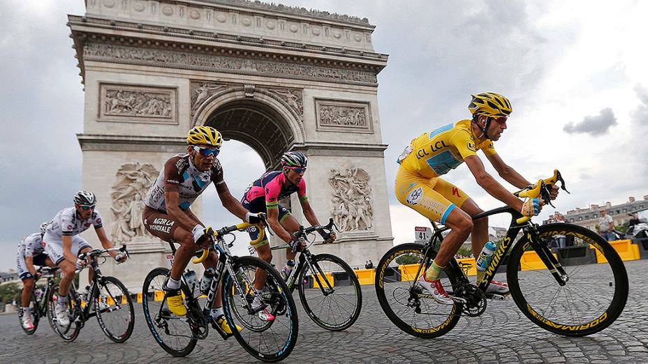 Atletas passam pelo Arco do Triunfo, em Paris, na última etapa do Tour de France