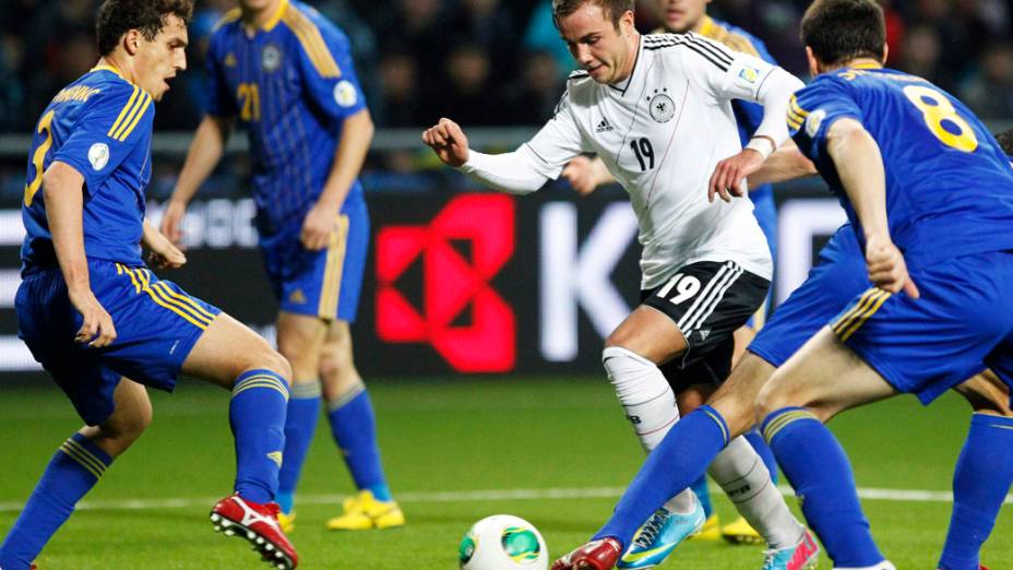 Jogador da Alemanha disputa a bola contra os jogadores do Cazaquistão