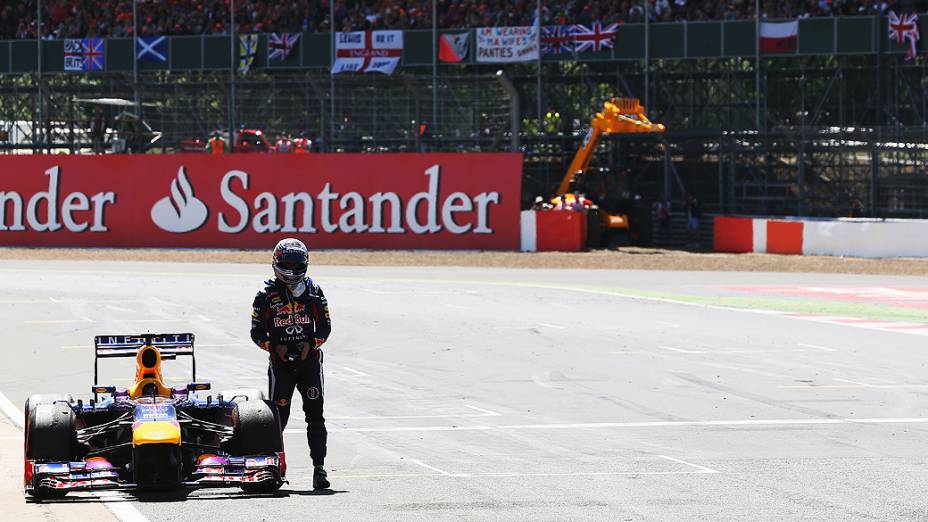 Sebastian Vettel da Alemanha e da Infiniti Red Bull Racing abandona a corrida reta principal com falha de motor durante o GP no Circuito de Silverstone