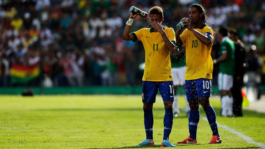 Neymar e Ronaldinho Gaúcho bebem água durante amistoso da seleção brasileira contra a Bolívia, em Santa Cruz de La Sierra