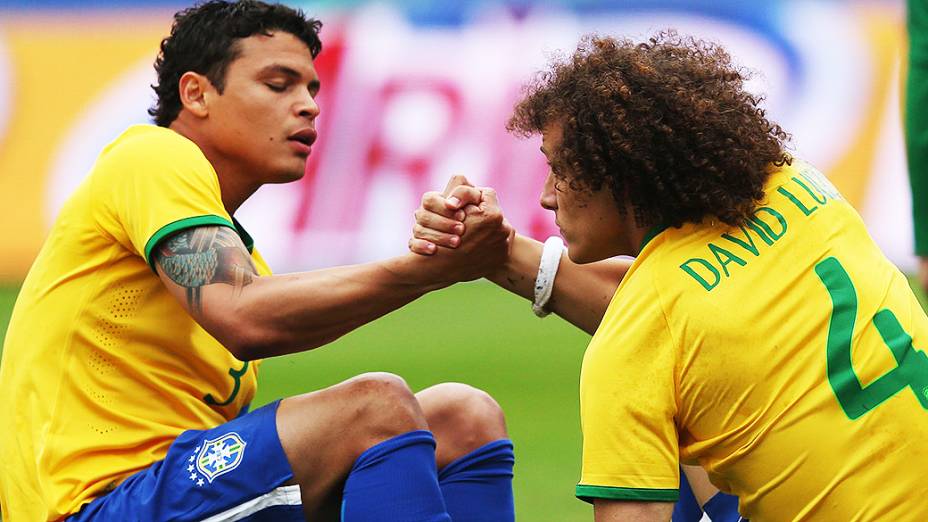 Thiago Silva ajuda David Luiz a se levantar durante amistoso contra a Sérvia, em São Paulo