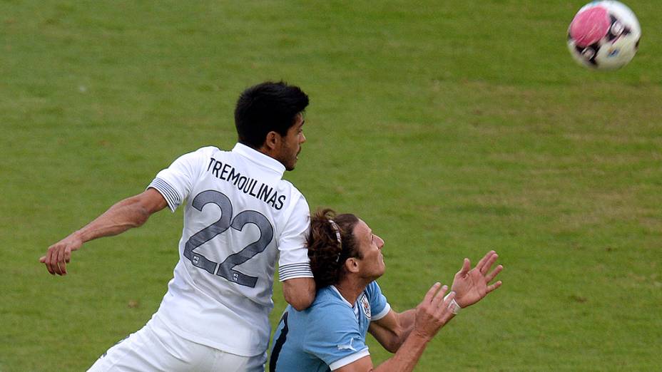 Diego Forlán, do Internacional em disputa de bola contra o francês Tremoulinas, durante amistoso entre as seleções em Montevidéu