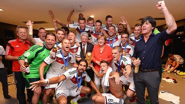 Angela Merkel comemora a conquista da Copa do Mundo com os jogadores e comissão técnica da seleção alemã nos vestiários do Maracanã