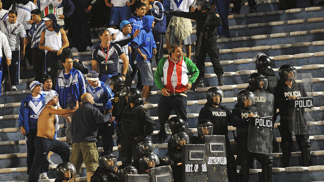 Polícia discute com torcedores do Vélez Sársfield durante partida contra o Peñarol, no estádio Centenário, em Montevidéu, válido pela Copa Libertadores da América