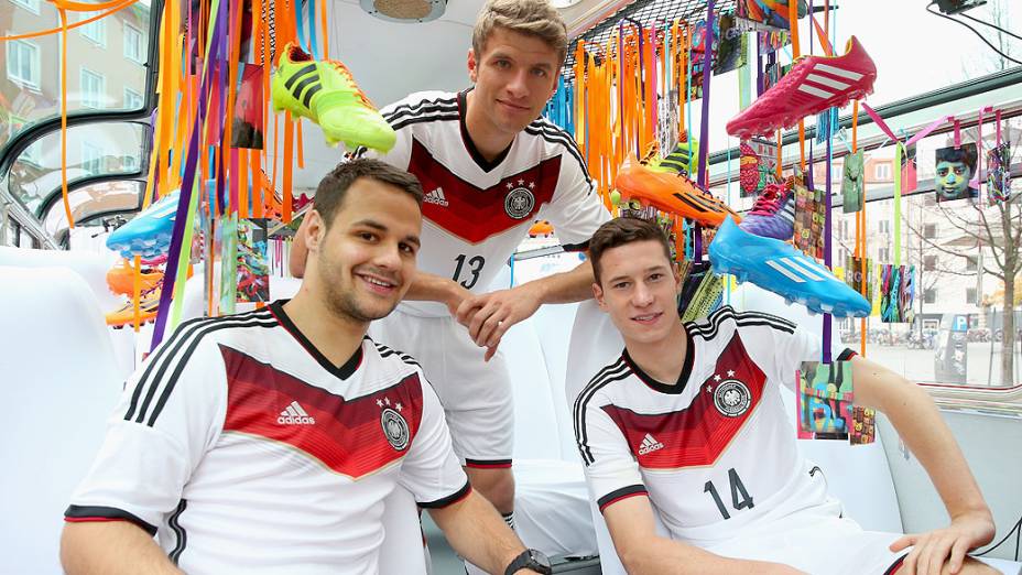 Thomas Mueller (centro) e Julian Draxler (à dir.), jogadores da Alemanha, com as novas camisas que a seleção usará na Copa do Mundo de 2014