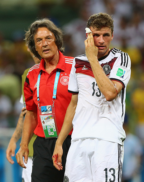O alemão Thomas Müeller sangra após lance com jogador de Gana