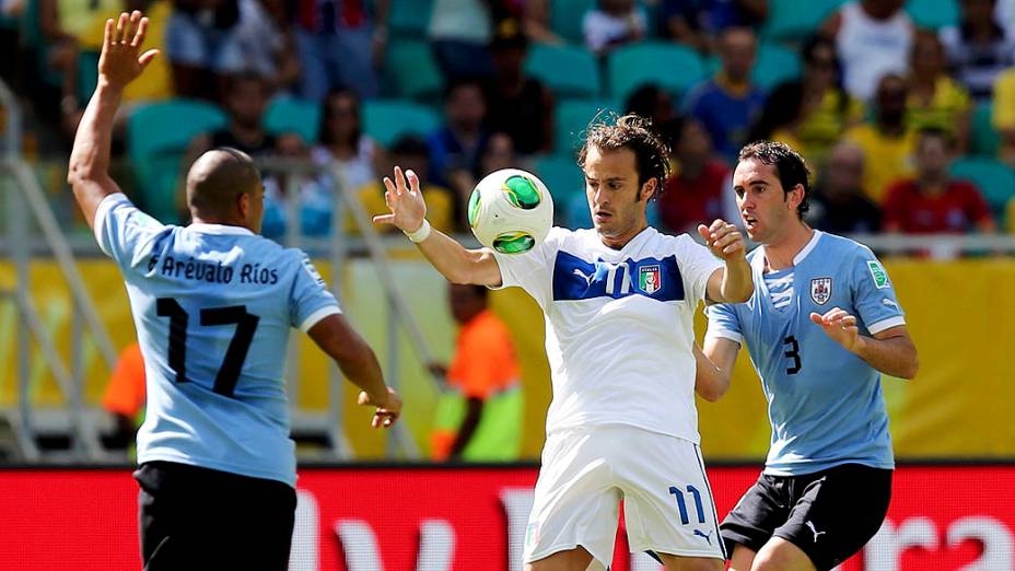 Da Itália, Alberto Gilardino controla a bola entre o Uruguai Diego Godin e Egidio Arevalo durante a Copa das Confederações terceiro lugar na Arena Fonte Nova, em Salvador